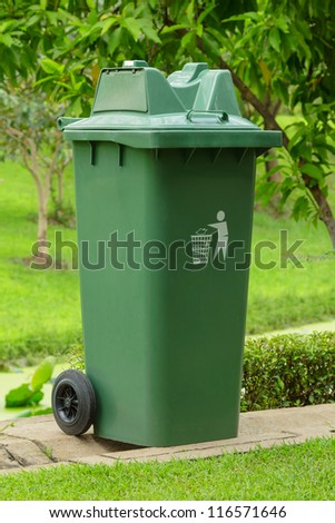 Large outdoor green garbage bin in a park