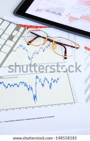 Tablet computer and financial charts for stock investment analysis concept