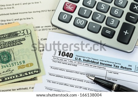 Tax form with pen, calculator, and dollar banknote taxation concept