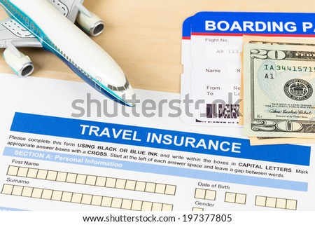 Travel insurance application form with plane model, boarding pass, and banknote