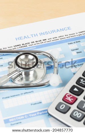 Health insurance application form with calculator and stethoscope concept for life planning