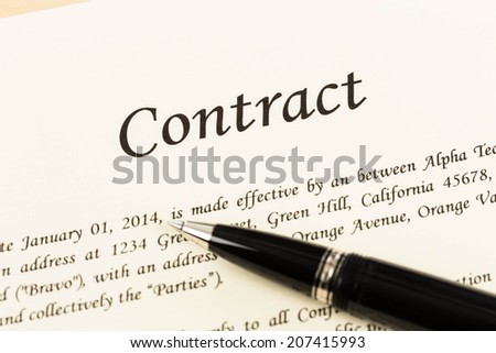 Business contract document on cream color paper and pen