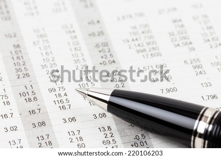Pen rest on stock price detail financial newspaper