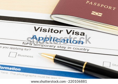Visa application form with passport and pen