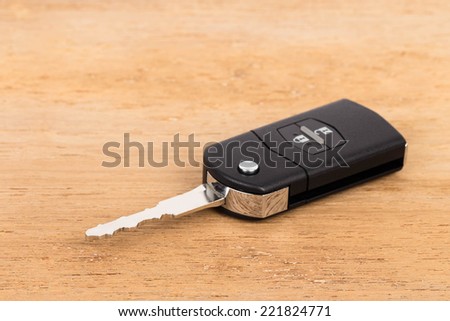Modern remote car key on wooden background