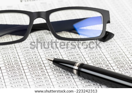 Finance report analysis with pen, and glasses