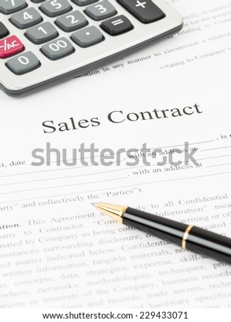 Sales contract document with calculator and pen