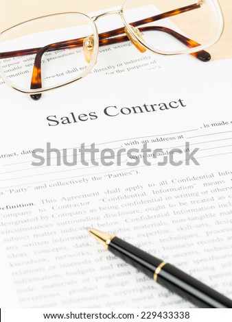 Sales contract document with glasses and pen