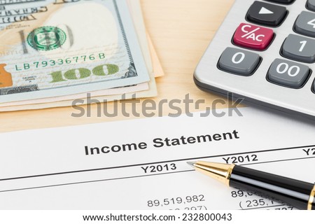 Income statement financial report with pen and calculator