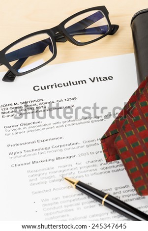 Curriculum vitae or CV with pen, glasses, organizer, and neck tie; concept job applying