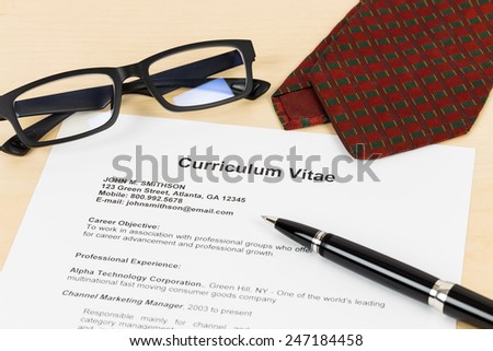 Curriculum vitae or CV with pen, glasses, and neck tie; concept job applying