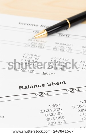 Balance sheet financial report with pen