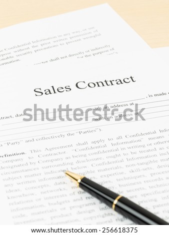 Sales contract document with pen, document is mock-up