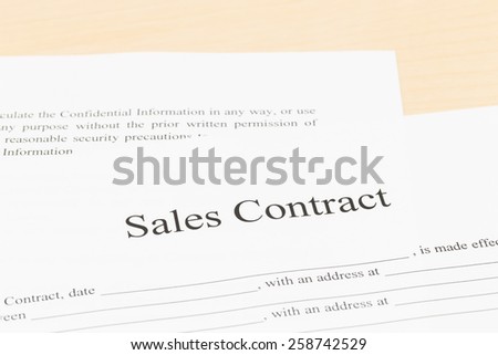 Sales contract on desk; document is mock-up
