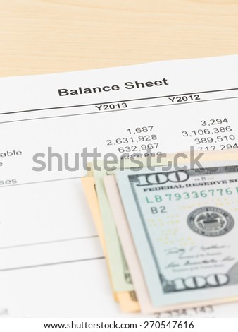 Balance sheet financial report with banknote, document is mock-up