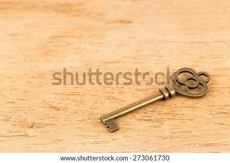 Antique key on wooden background