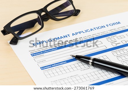 Employment application form with pen and glasses; form is mock-up