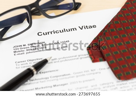 Curriculum vitae or CV with pen, glasses, and neck tie; CV and information are mock-up.