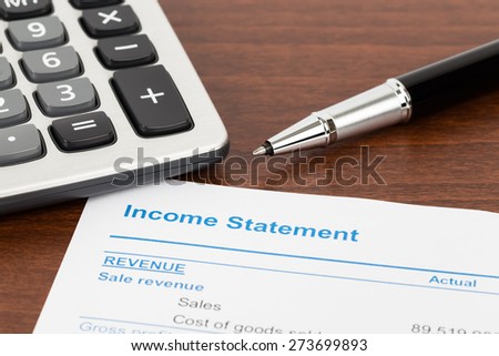 Income Statement report with pen and calculator; document is mock-up