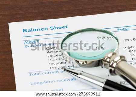 Balance Sheet report with pen and magnifier; document is mock-up