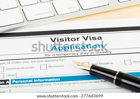 Visa application form with keyboard and pen; form is mock-up