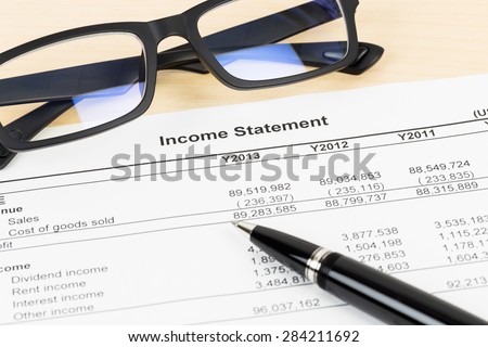 Income statement financial report with glasses and pen;  document is mock-up