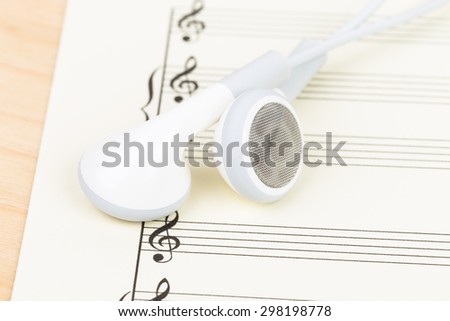 Earphone on  cream color paper music score