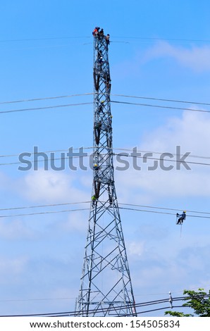 electrician worker at climbing work on high voltage post