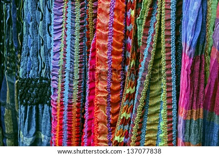 Colored scarves of various materials, exposed to sale.