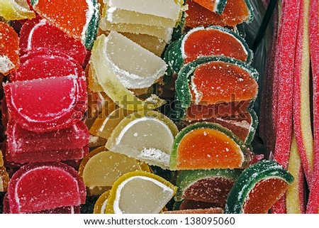 Colorful jellys in fruit slices shaped with colored jellies on belt shape with sugar. Homemade sweets.