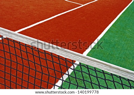 Sports field with synthetic turf, markings and netting used in tennis.Detail.