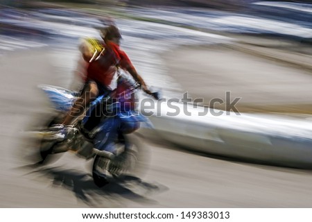 Abstract image with a moving motorcycle on blurred background.