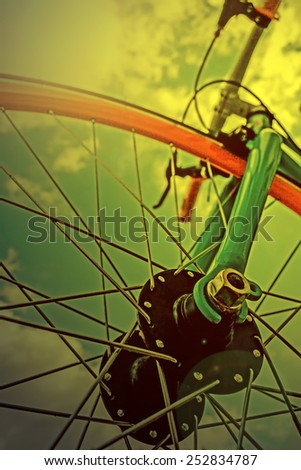 Vintage look at one bicycle detail on a background of sky, in the morning light.
