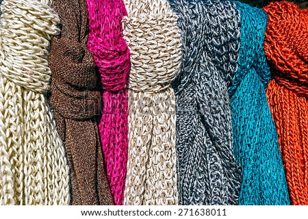 Wool scarves of various colors, exposed for sale.