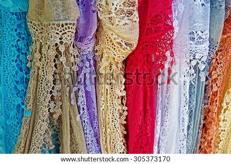 Colored lace scarves hanging and exposed for sale.