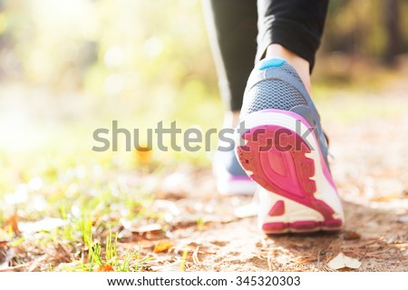 Woman running legs in sunset forest