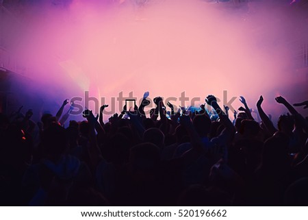 silhouettes of a massive crowd at the party concert club music happy