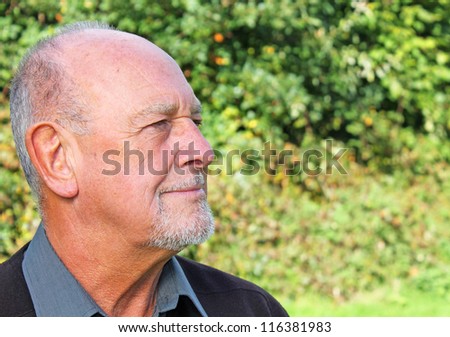 Handsome senior man smiling to himself