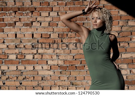 Beautiful young woman near brick wall