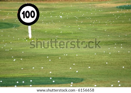 100 yard sign and golf balls at a driving range