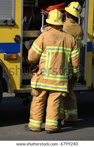 Firefighters removing gear from a firetruck