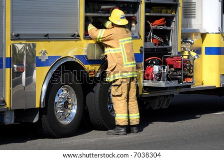 Firefighter getting gear from the fire truck