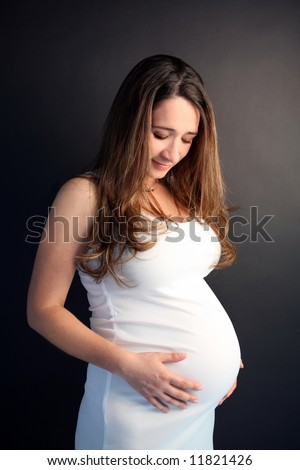 pregnant belly pictures. holding her pregnant belly