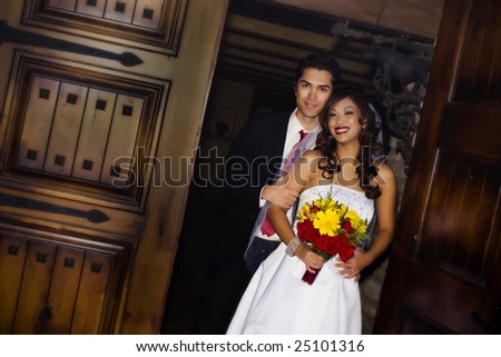 Happy young wedding couple in church entrance