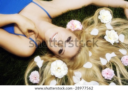 Beautiful woman laying in the grass with flowers in her hair