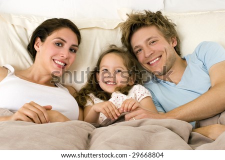 Happy family laying in bed
