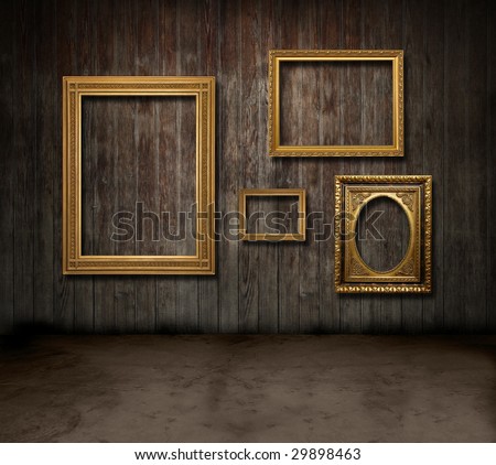 Empty gold frames hanging in a dark wooden room
