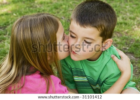 Sister giving her brother a kiss on the cheek