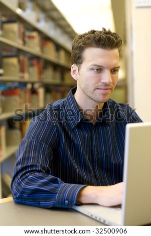 Nice young man researching information on a laptop