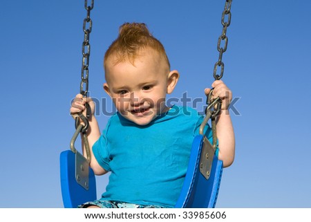 Toddler at the beach on a swing
